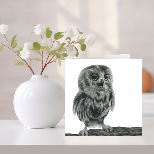 A charming hand-drawn owl greeting card, printed on Libra Fine Arts cardstock for a high-quality finish. The card is placed on a shelf beside a bouquet of flowers, creating a warm and inviting display. Blank inside, making it perfect for birthdays, thank you notes, or any heartfelt message. A lovely choice for nature and wildlife enthusiasts.