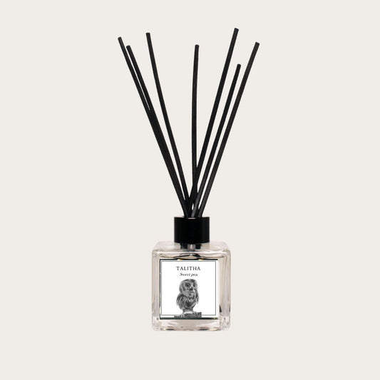 A Sweet Pea Luxury Reed Diffuser featuring a sleek glass bottle with reeds, releasing a fragrant, soothing sweet pea scent to enhance the ambiance of any space